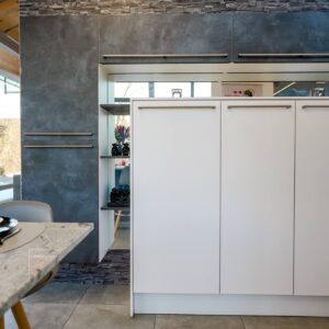 inselkueche mit tresen und steinplatte mit hochschrank
