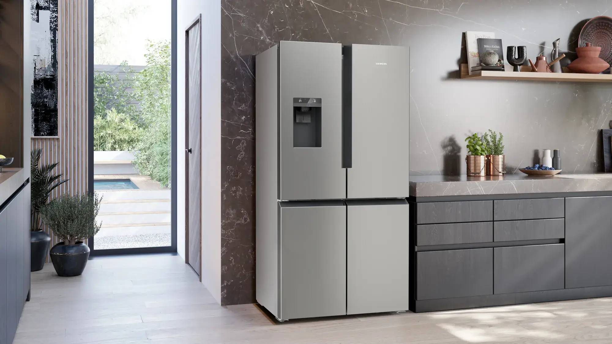 Siemens French Door Kühlschrank aus Edelstahl neben einer dunklen Küchenzeile